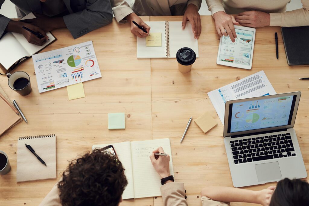 Personen aan een tafel met een laptop en schriften
